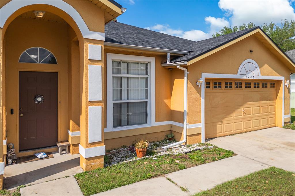 2782 Andes Way St. Cloud, FL 34769 - Photo 11 of 42 a front view of a house with a garden