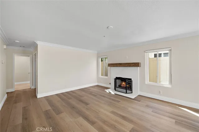 an empty room with fireplace and wooden floor