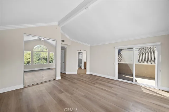 an empty room with wooden floor and a window