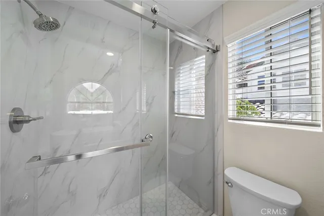 a bathroom with a toilet and a shower