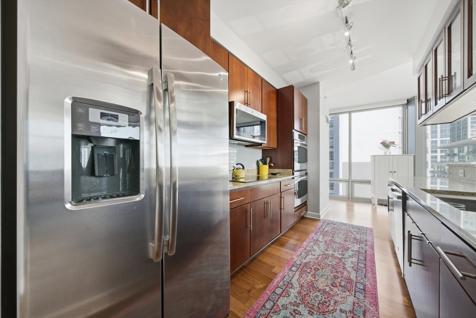 100 East 14th Street, Unit 1401 Chicago, IL 60605 - Photo 9 of 28 a large kitchen with stainless steel appliances a refrigerator and a stove