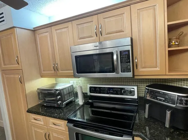 a kitchen with granite countertop a stove and a microwave
