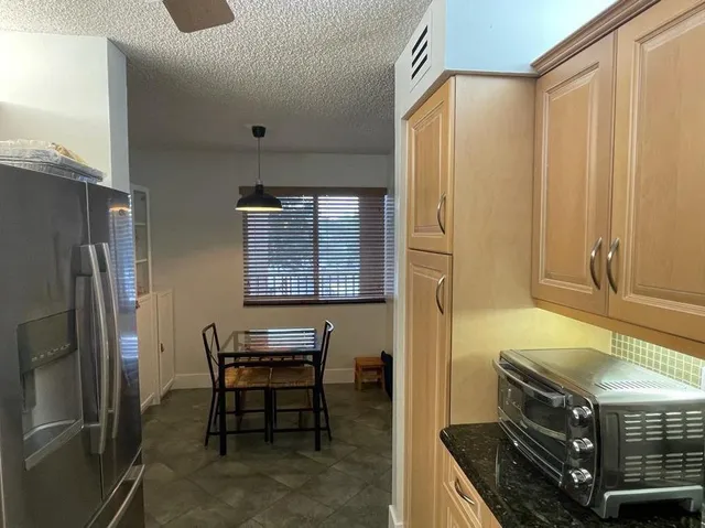 a kitchen with stainless steel appliances granite countertop a refrigerator and a stove