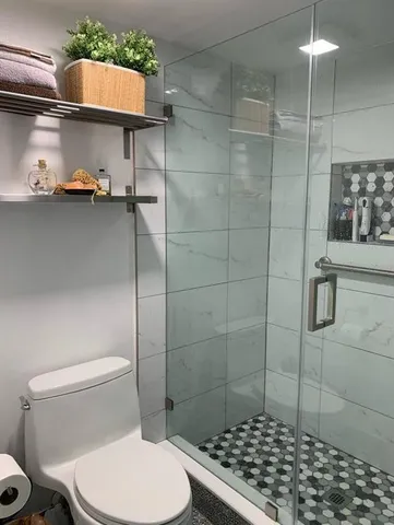 a bathroom with a toilet a sink a shower and curtain