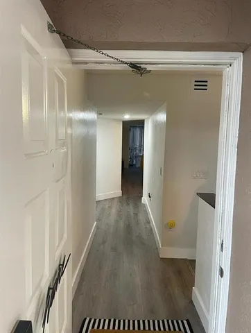 a view of a hallway with wooden floor
