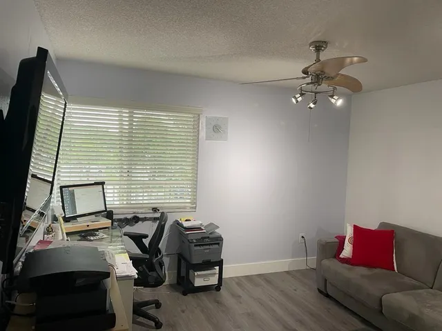 a view of a workspace with furniture and a window
