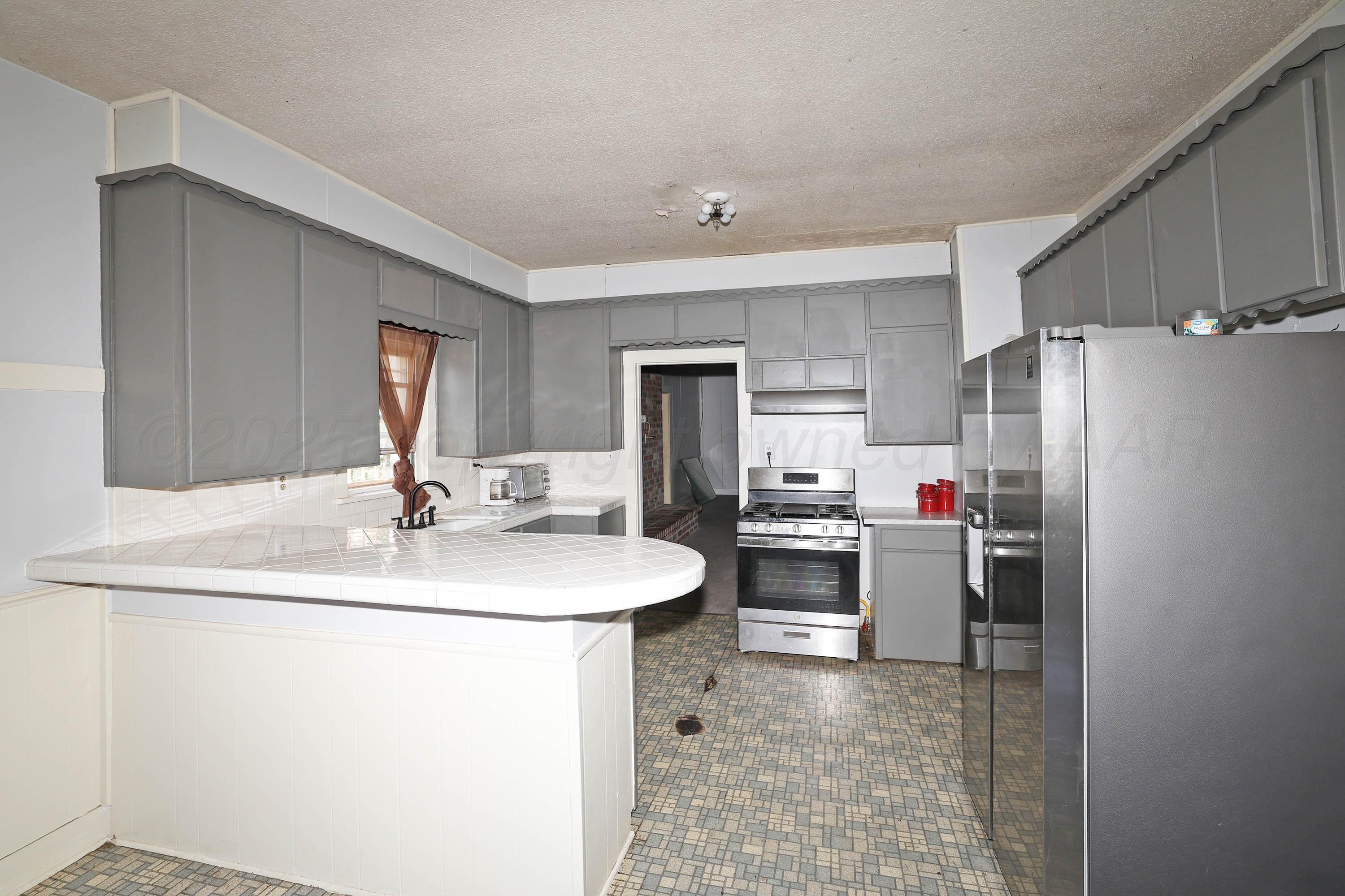 2001 Northwest 13th Avenue Amarillo, TX 79107 - Photo 11 of 35 a kitchen with refrigerator and chairs