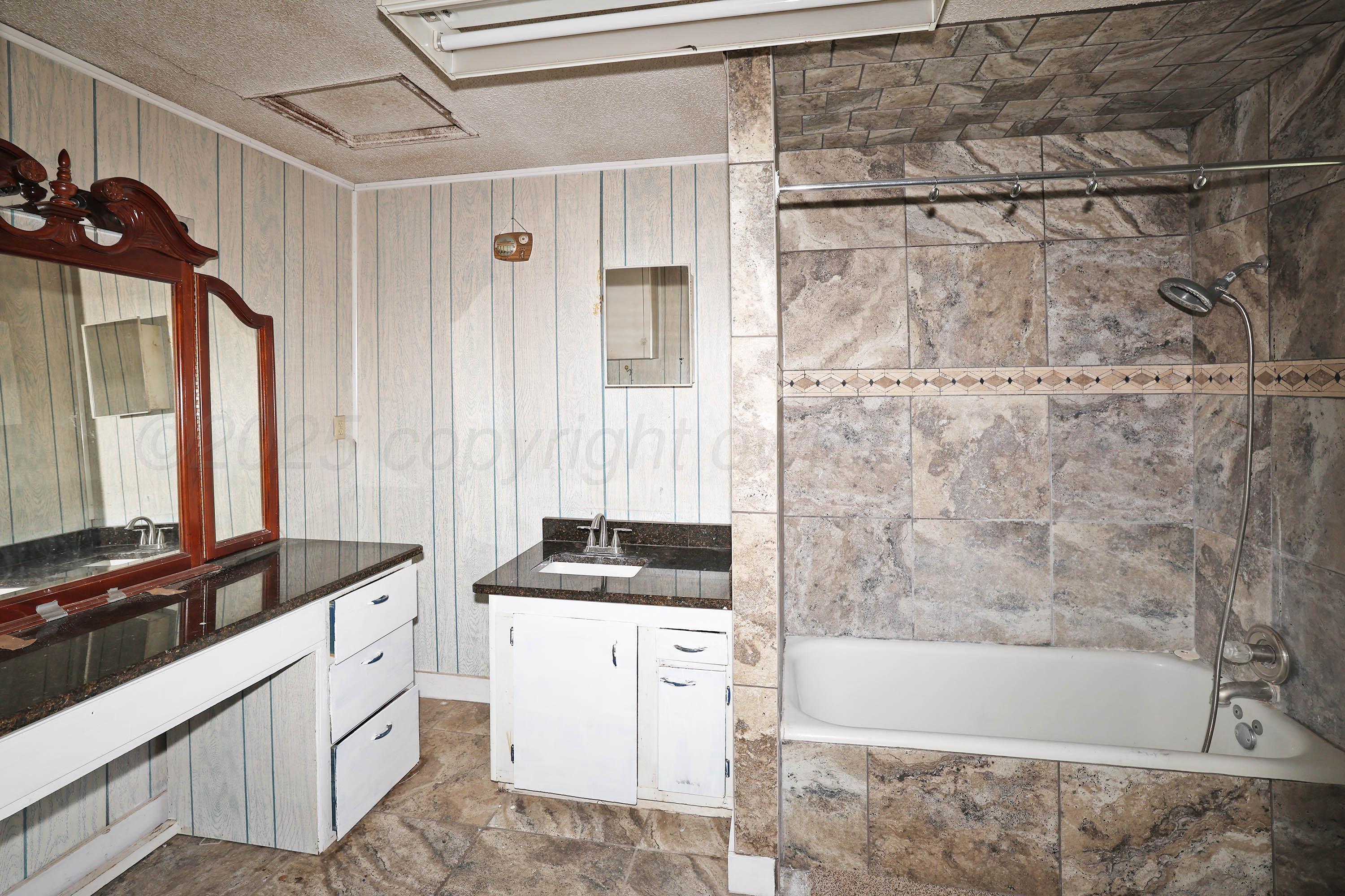 2001 Northwest 13th Avenue Amarillo, TX 79107 - Photo 14 of 35 a bathroom with a bathtub a sink a vanity and a shower