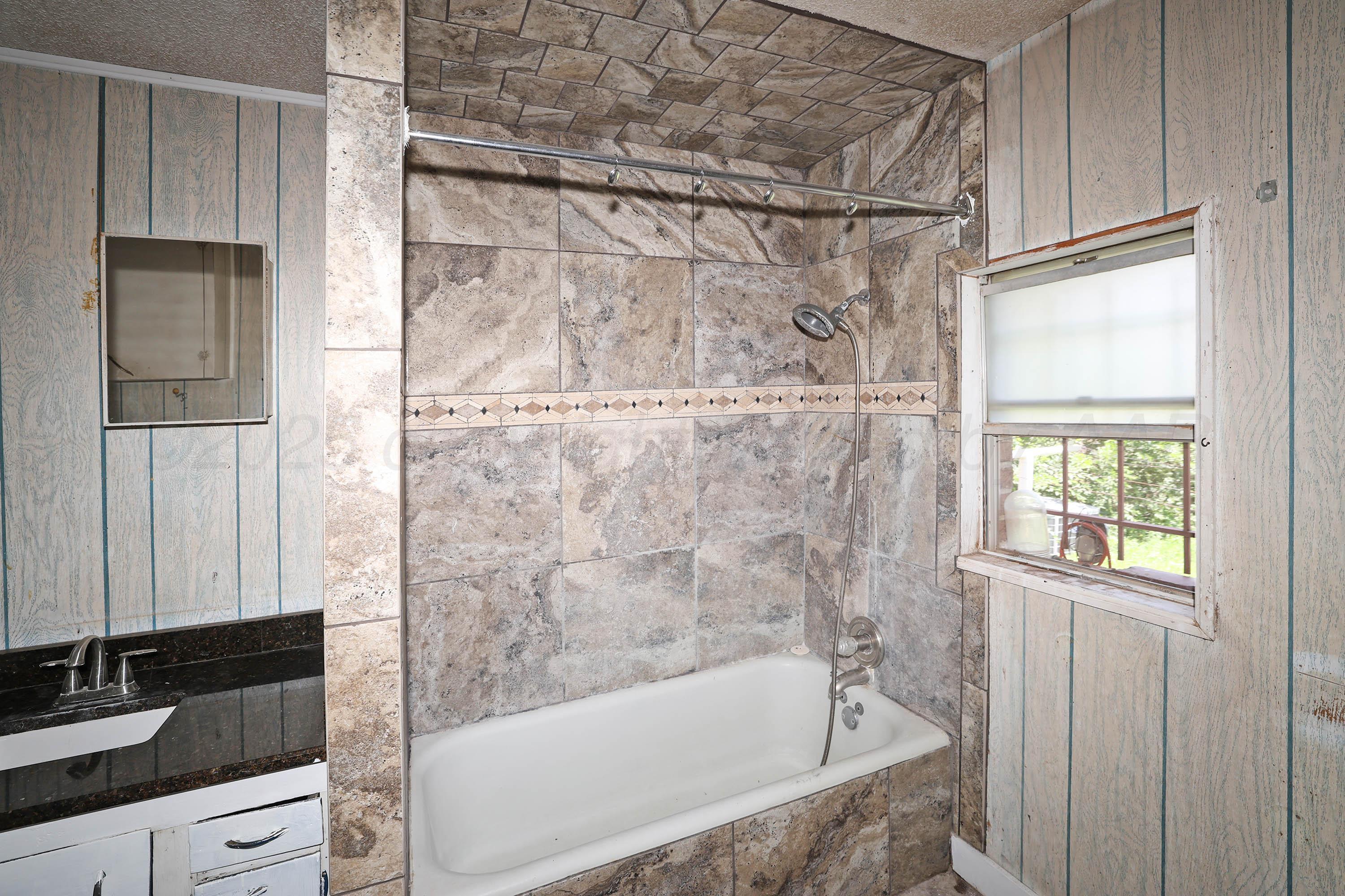 2001 Northwest 13th Avenue Amarillo, TX 79107 - Photo 16 of 35 a bathroom with a granite countertop bathtub shower and sink