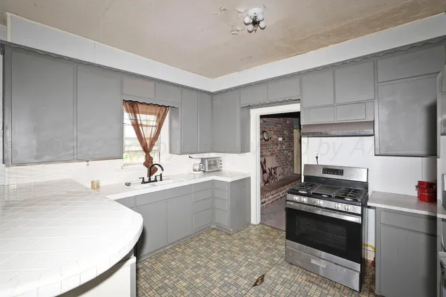 a kitchen with stainless steel appliances a stove a sink and cabinets