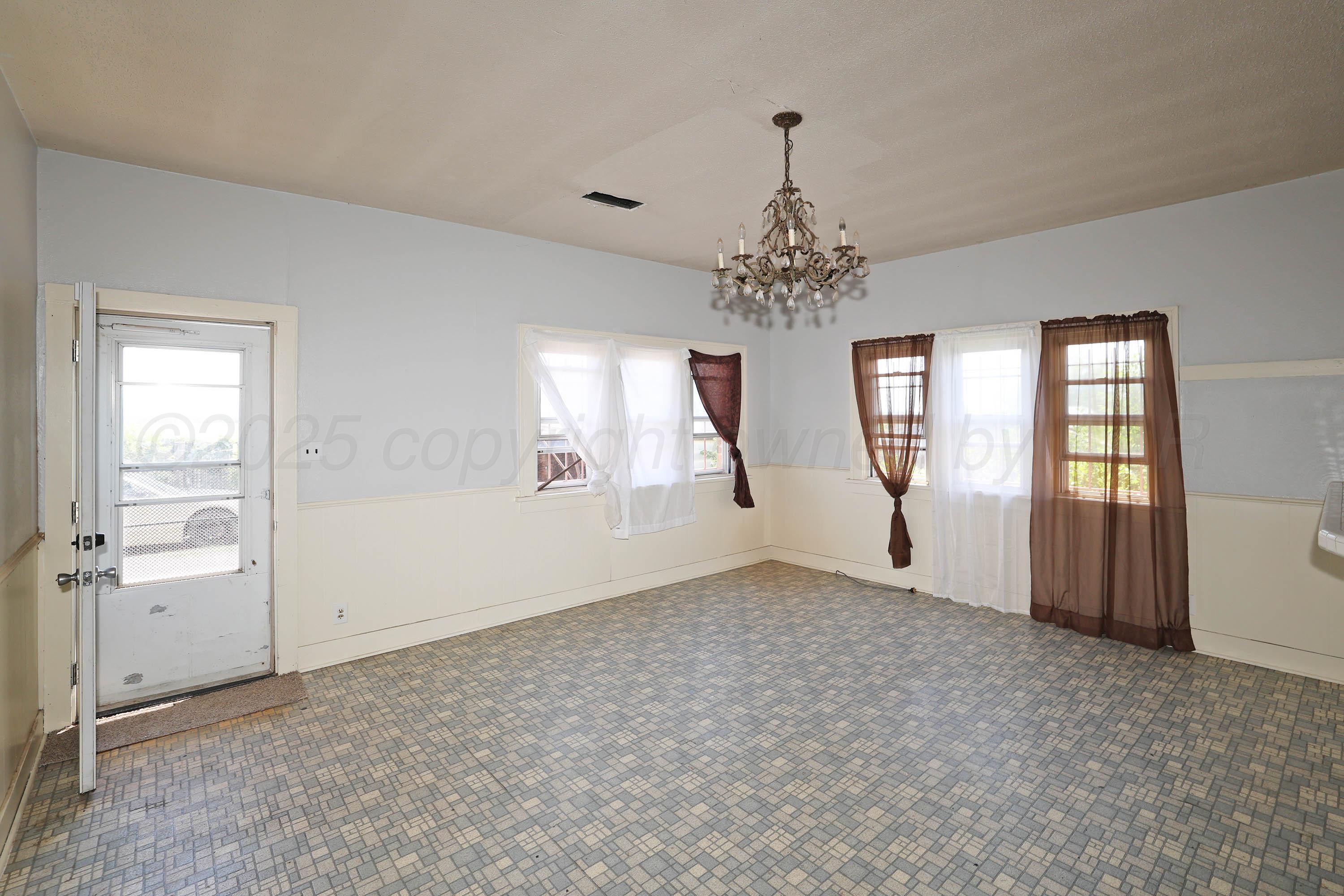2001 Northwest 13th Avenue Amarillo, TX 79107 - Photo 8 of 35 an empty room with chandelier and windows