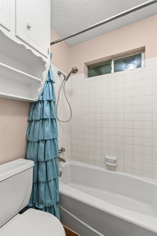 505 Pinewood Lane Hewitt, TX 76643 - Photo 24 of 38 Bathroom featuring a white porcelain bathtub, white square wall tile, and a handheld shower fixture