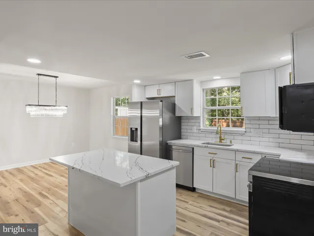a kitchen with stainless steel appliances a sink stove and refrigerator
