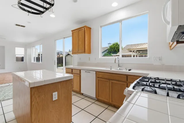 a kitchen with cabinets appliances a sink and a window