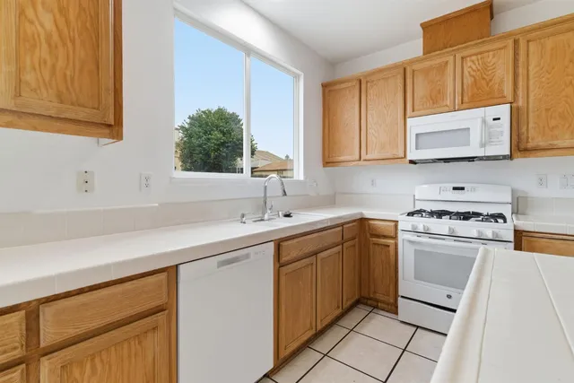 a kitchen with a sink a counter top space cabinets and stainless steel appliances