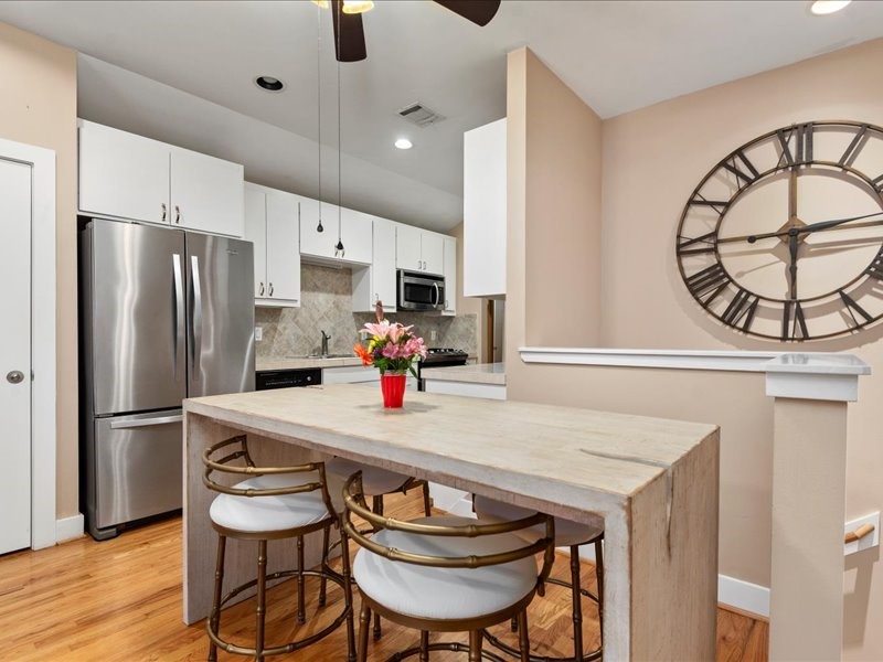 5941 South Loop E Freeway, Unit 504 Houston, TX 77033 - Photo 20 of 39 a kitchen with stainless steel appliances a table chairs and a refrigerator