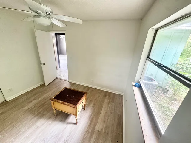a view of a living room with wooden floor and furniture