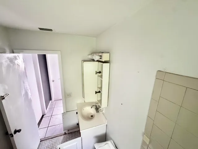 a bathroom with a sink and mirror with toilet