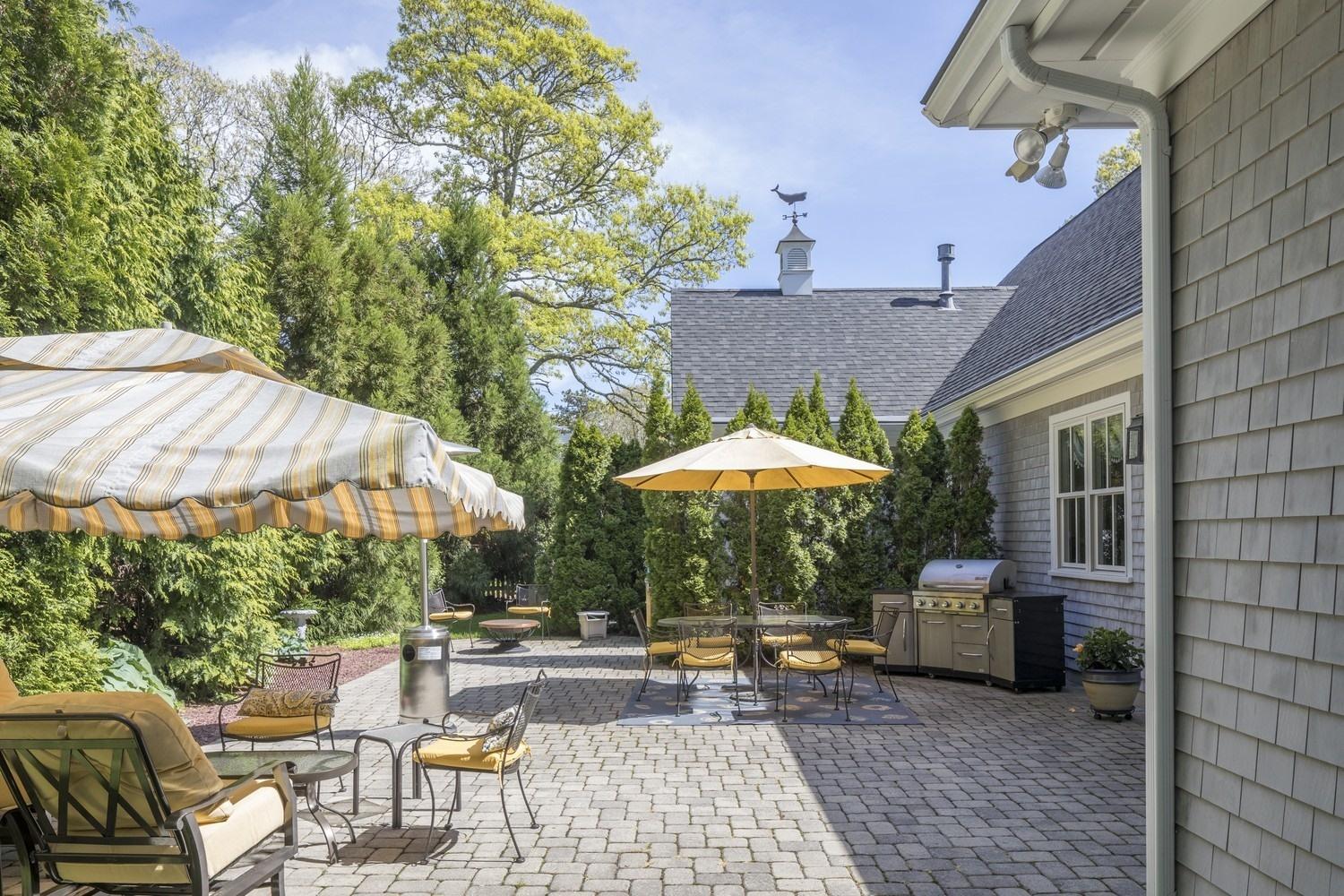 30 Barnard Road Osterville, MA 02655 - Photo 3 of 18 a view of a patio with chairs and table under an umbrella with a barbeque