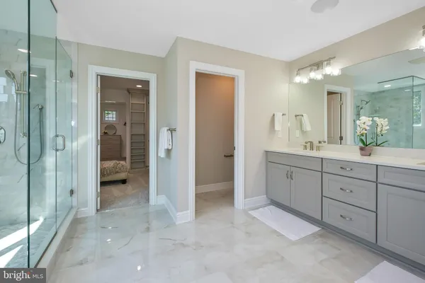 a bathroom with a sink vanity granite tub and a mirror