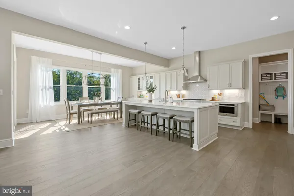 a kitchen with stainless steel appliances granite countertop a table chairs stove a sink dishwasher and cabinets