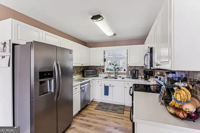 a kitchen with stainless steel appliances granite countertop a refrigerator and a sink