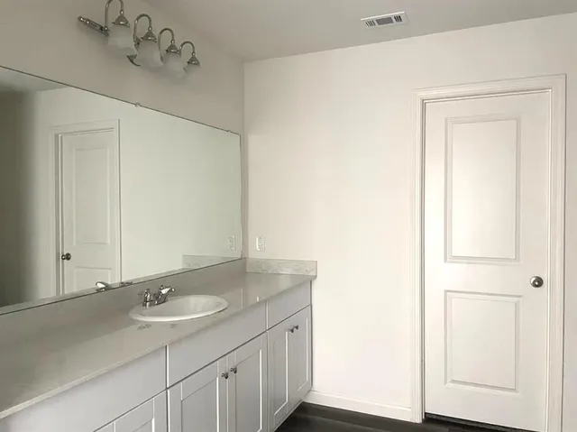 a bathroom with a granite countertop sink and a mirror