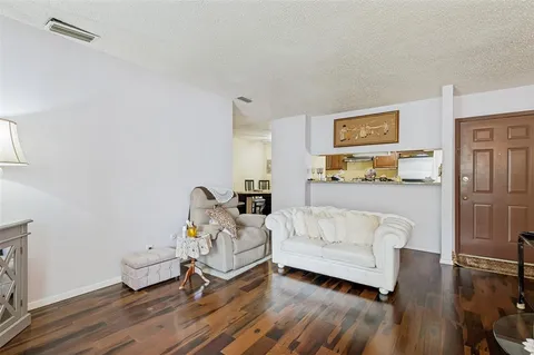 a living room with furniture and a wooden floor