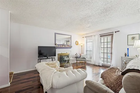 a living room with furniture wooden floor and a flat screen tv