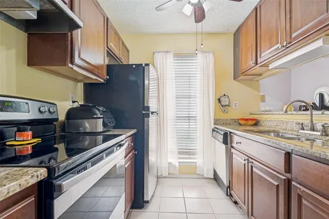 a kitchen with stainless steel appliances granite countertop a sink stove and cabinets