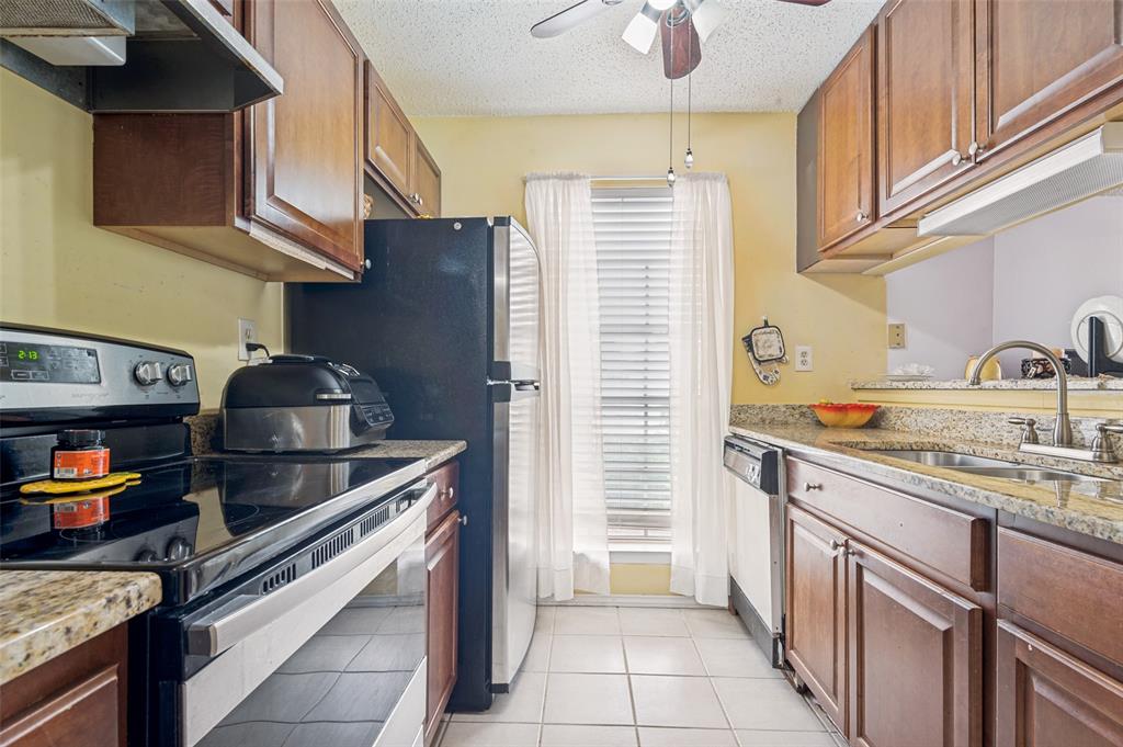 5981 Arapaho Road, Unit 309 Dallas, TX 75248 - Photo 7 of 13 a kitchen with stainless steel appliances granite countertop a sink stove and cabinets