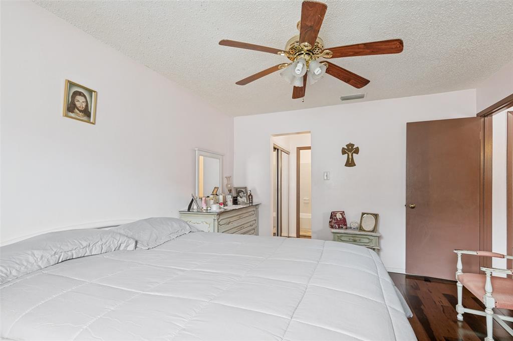 5981 Arapaho Road, Unit 309 Dallas, TX 75248 - Photo 9 of 13 a bedroom with a bed and a chandelier