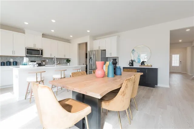 a kitchen with stainless steel appliances kitchen island granite countertop a kitchen island a stove a table and chairs