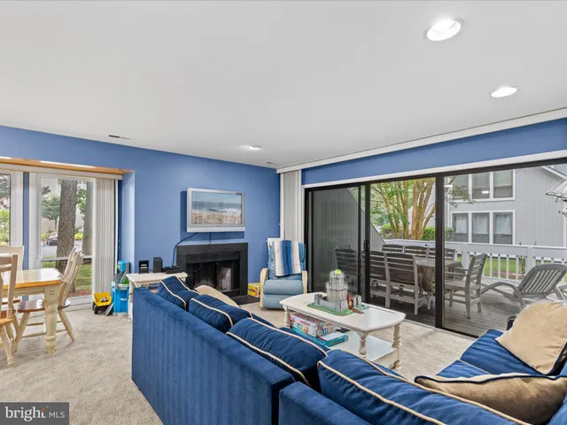 a living room with furniture a fireplace and a floor to ceiling window