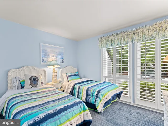 a bedroom with two beds and a large window