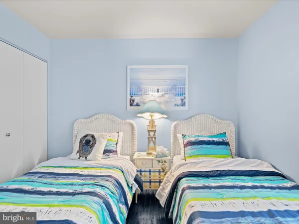 a bedroom with two beds and painting on the wall