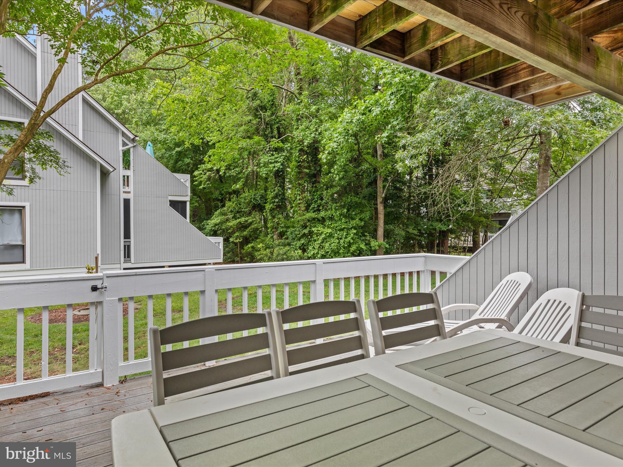 39346 Racquet Lane, Unit 8502 Bethany Beach, DE 19930 - Photo 29 of 33 a view of a wooden deck with a bench