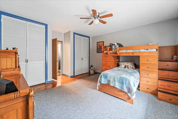 a bedroom with furniture and a chandelier fan