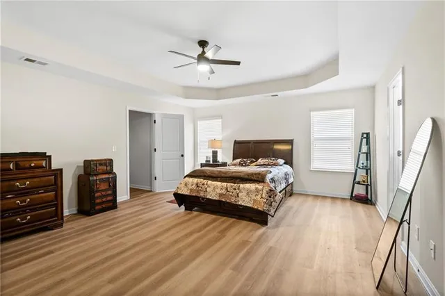 a bedroom with a bed a dresser and next to a window