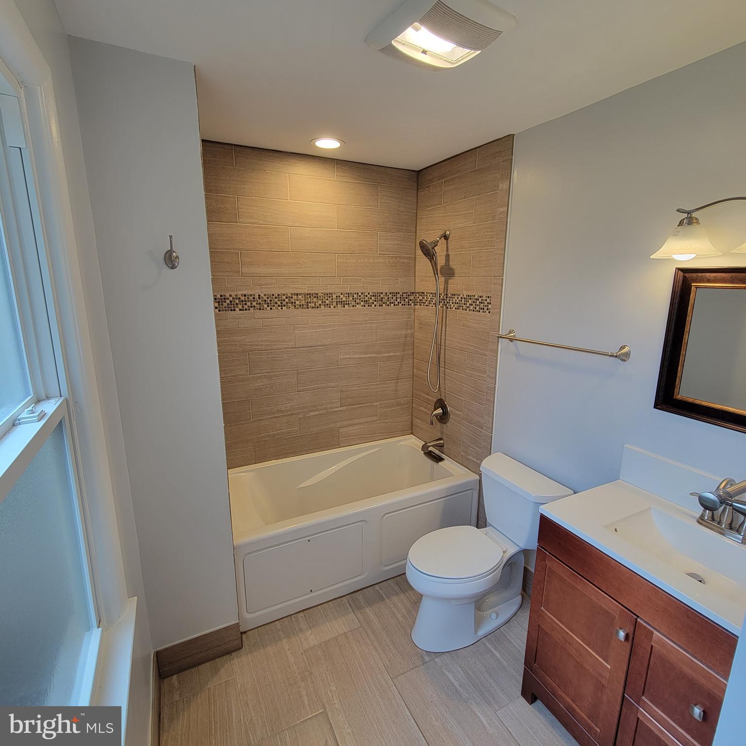 18320 Metz Drive Germantown, MD 20874 - Photo 13 of 31 a bathroom with a bathtub shower sink vanity mirror and toilet