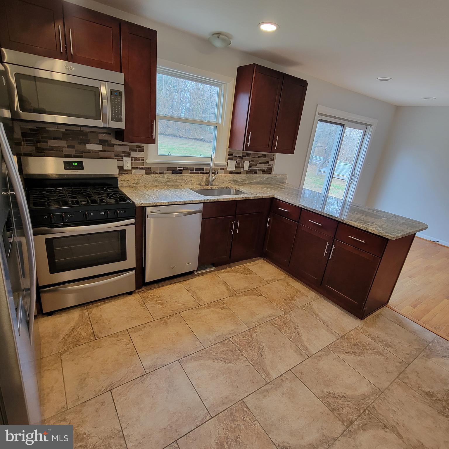 18320 Metz Drive Germantown, MD 20874 - Photo 3 of 31 a kitchen with stainless steel appliances a stove a sink and a microwave