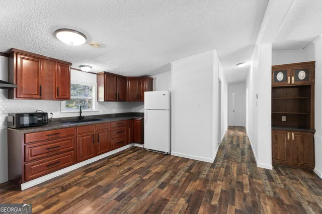 a kitchen with stainless steel appliances granite countertop a refrigerator and a stove top oven