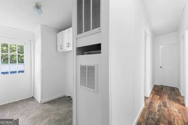 an entryway with wooden floor and windows