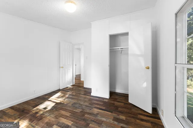a view of a room with wooden floor and a window