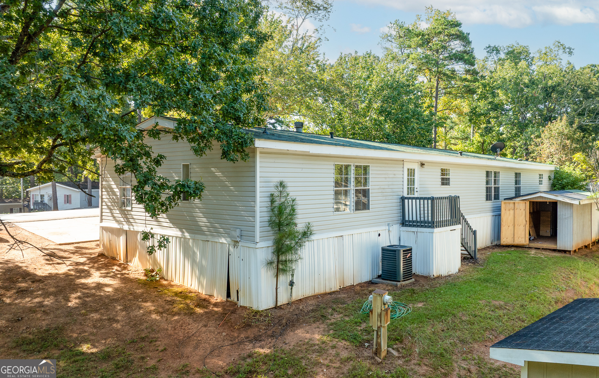 4653 Whispering Pines, Unit 449 Buford, GA 30518 - Photo 5 of 33 a white house that has tree in front of it