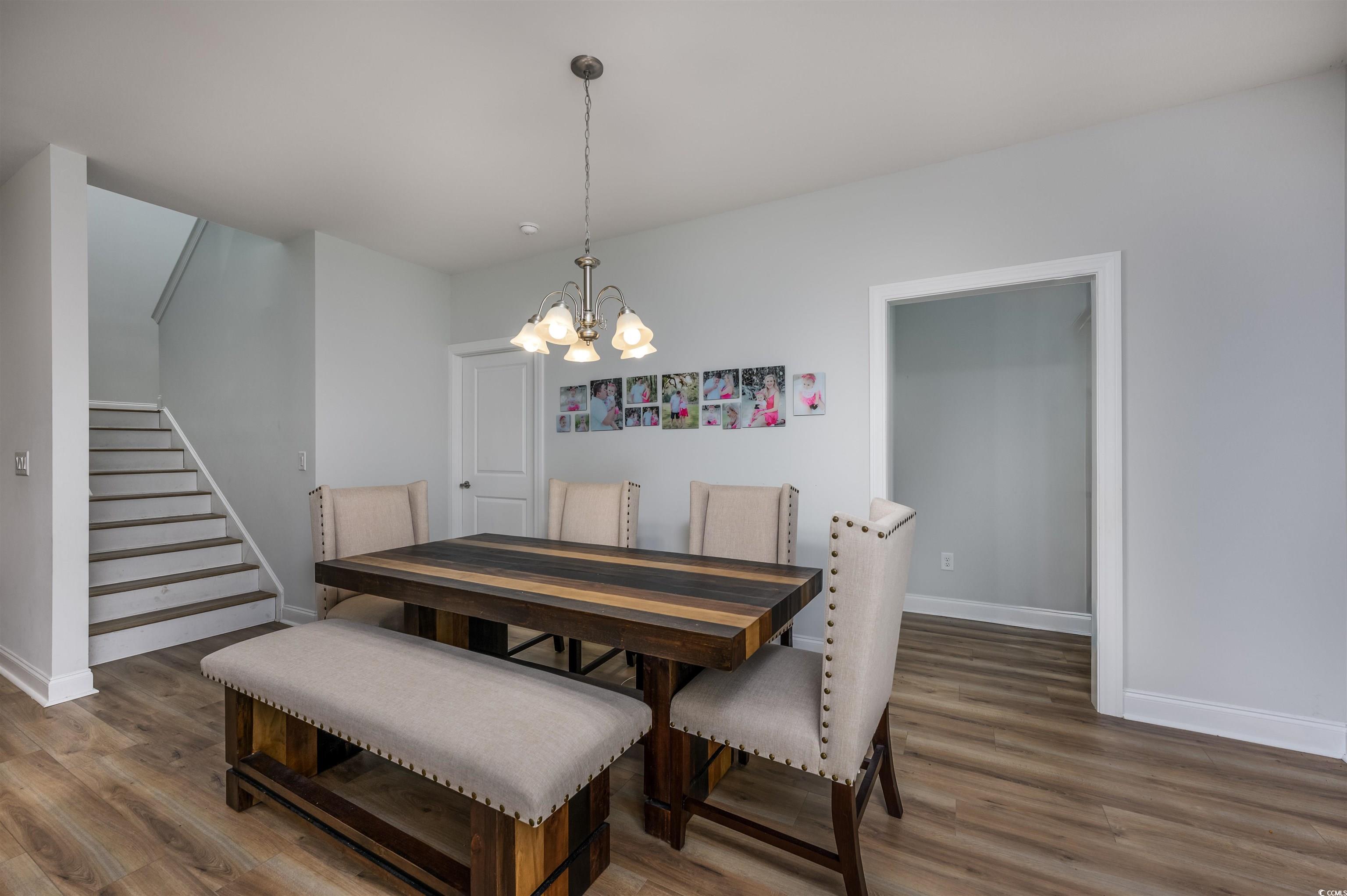2550 Dogwood Road Longs, SC 29568 - Photo 4 of 35 Dining room featuring stairs, wood finished floors, and a chandelier