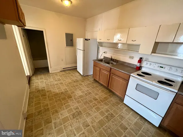a kitchen with a stove a refrigerator and a cabinets