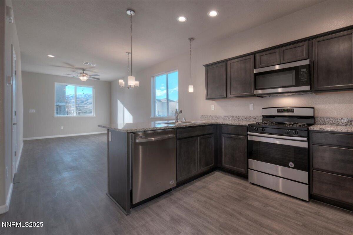 1168 Arrastra Road, Unit LOT 18 Reno, NV 89512 - Photo 8 of 24 a kitchen with stainless steel appliances granite countertop a stove a sink and a microwave