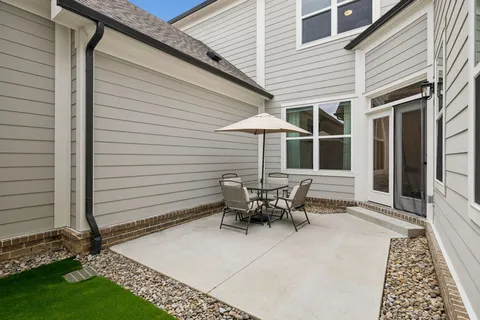a view of a patio with table and chairs with wooden fence