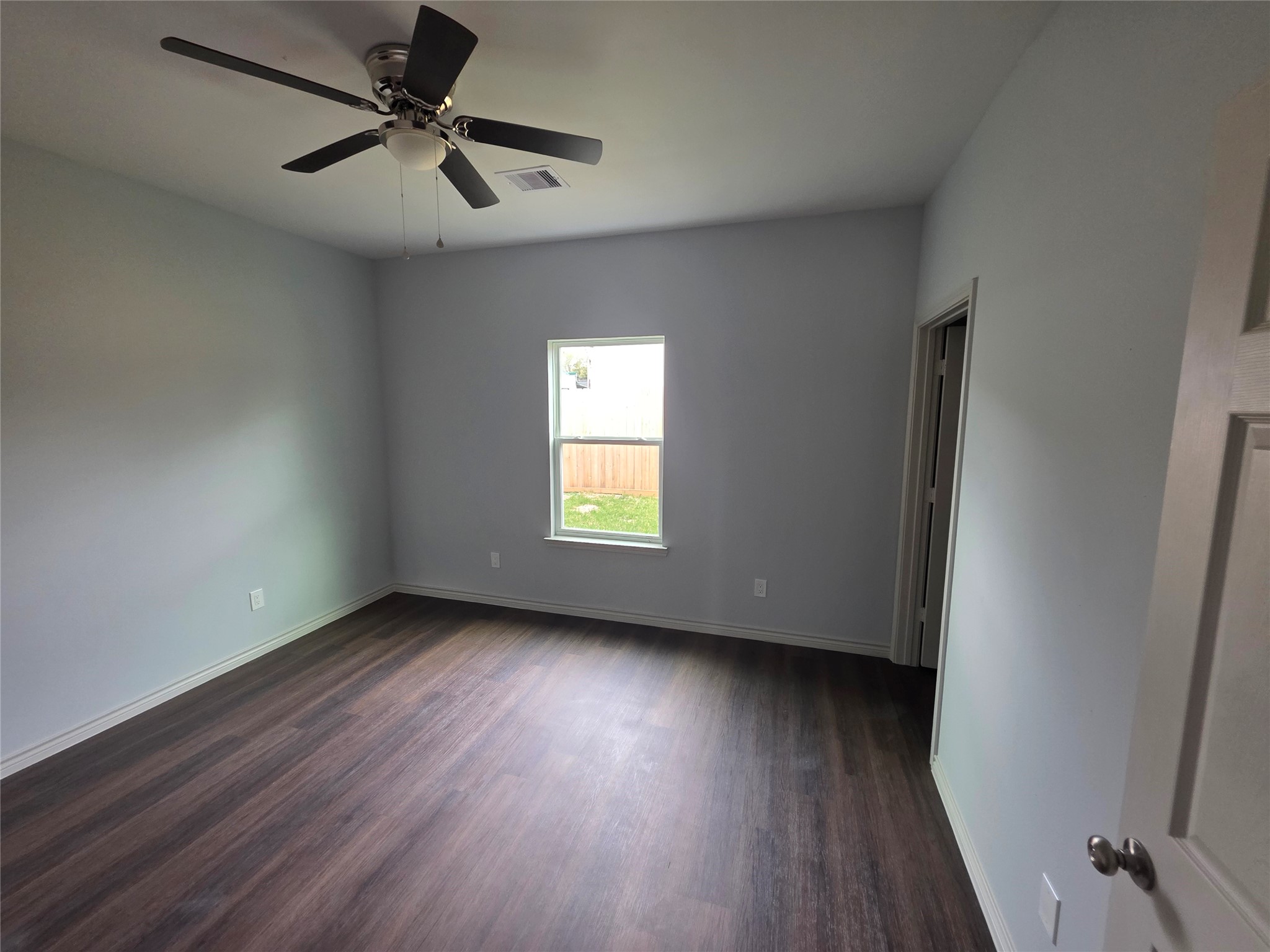 213 Dipping Stream Street Houston, TX 77076 - Photo 4 of 10 an empty room with wooden floor fan and windows